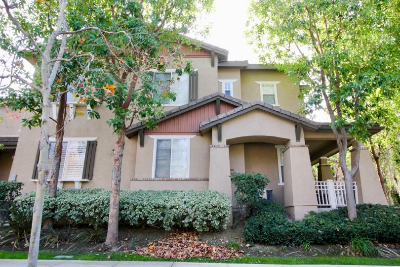 A view of the two story structure with plenty of windows and mature trees at Chambray in Ladera Ranch, California