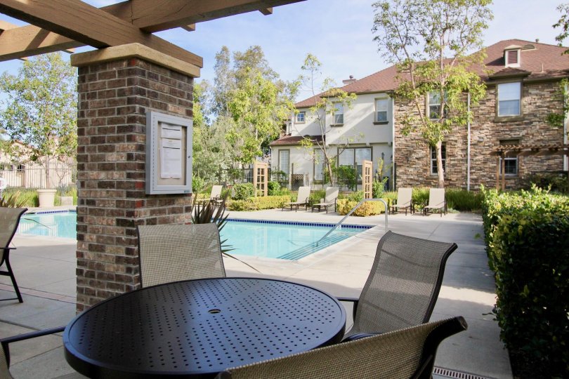 A sunny day in the area of Sycamore Grove, poolside, chair, patio, condo, bushes, stairs