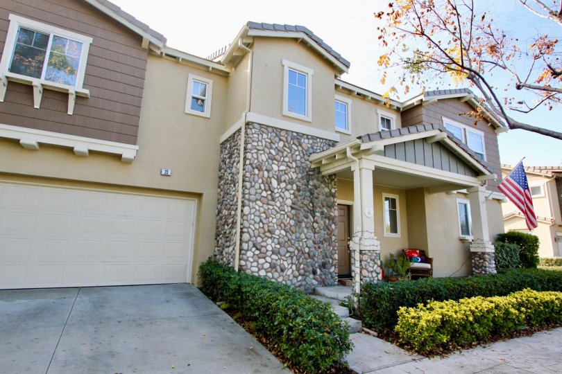 A Big villa with plants in front and USA Flag of Valmont of Ladera Ranch