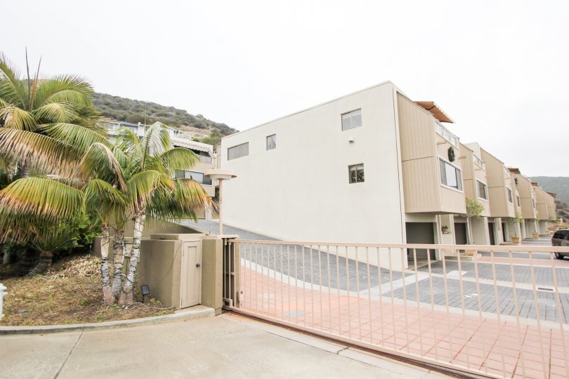 A driveway lined with pink bricks behind a security fence at Laguna Ocean Vista in Laguna Beach CA