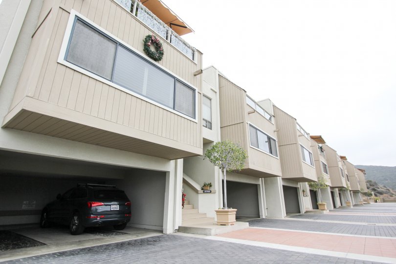 A day in the Laguna Ocean Vista with modern apartments and a vehicle.