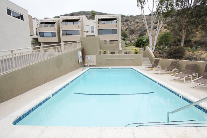 Buildings with view of a pool and hills in the Laguna Ocean Vista Community in Laguna Beach, CA.