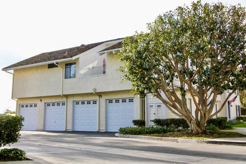 a sunny day in the sparrow hill with a house that has closed parking door in front of it with roofless top and has a balcony too