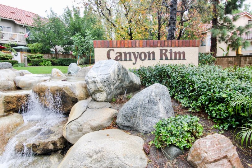 A sunny day in the area of Canyon Rim, trees, roof, condo, rocks, waterfall, sign
