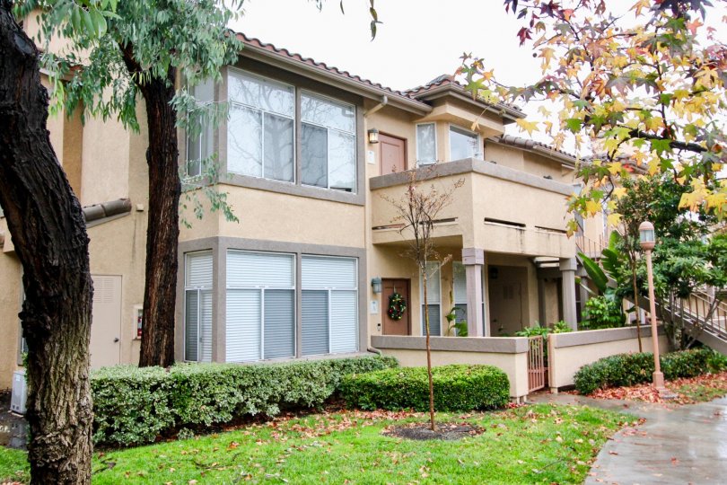 A apartment complex with bushes and trees around the building in Tuscany at Foothill Ranch community in Lake Forest, California.
