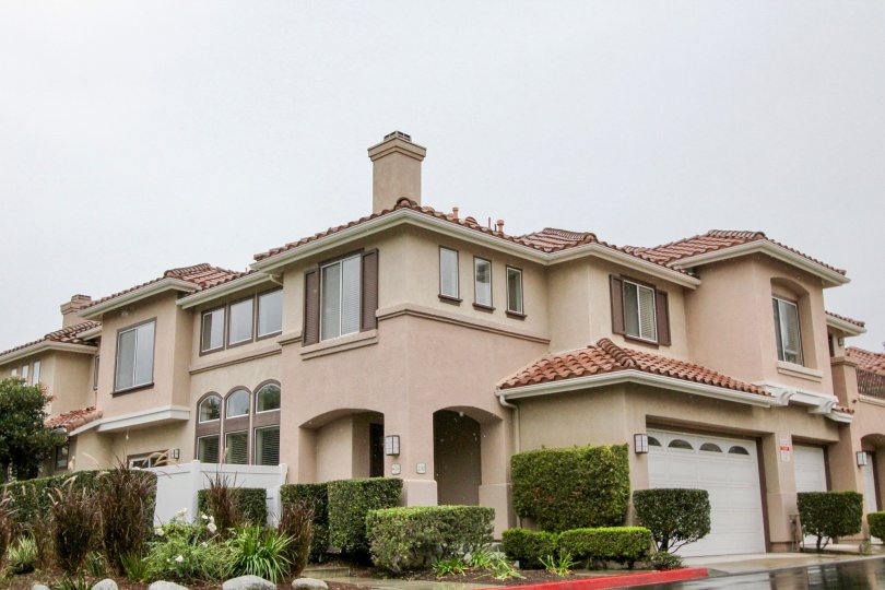 A very large tan home with bushes around it in California Terrace community in Mission Viejo, California.