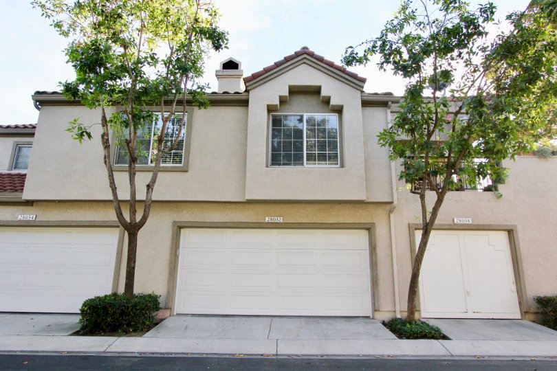 Shaded front of large house, garage and trees in Coral Gardens, Mission Viejo