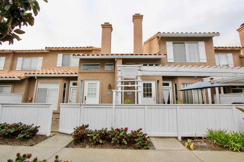 Outside view of condos and white privacy fence in Emerald Pointe I, Mission Viejo, California.