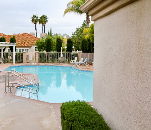 A sunny day in the Palmia Courts 2 with swimming pool and chairs.