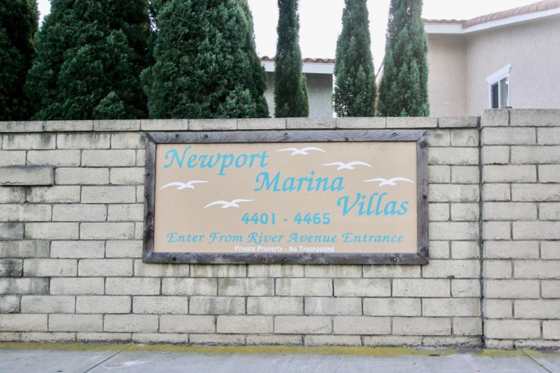 THE HOUSE IN THE NEWPORT MARINA VILLAS WITH THE NAME BOARD, TREES