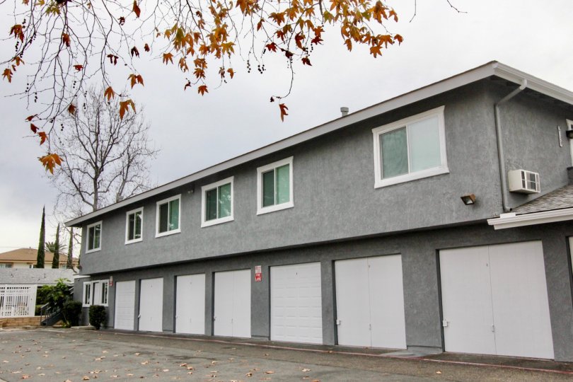 A gray apartment building in Stoneybrook Villas with white garages.