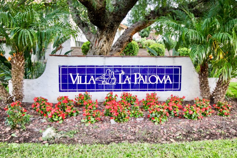 The sign outside the Villa La Paloma with flowers and palm trees