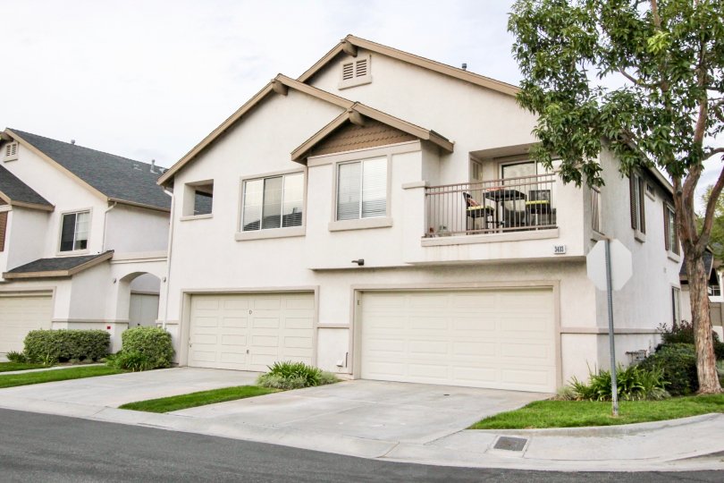 A white two story house in Westbury with two garages