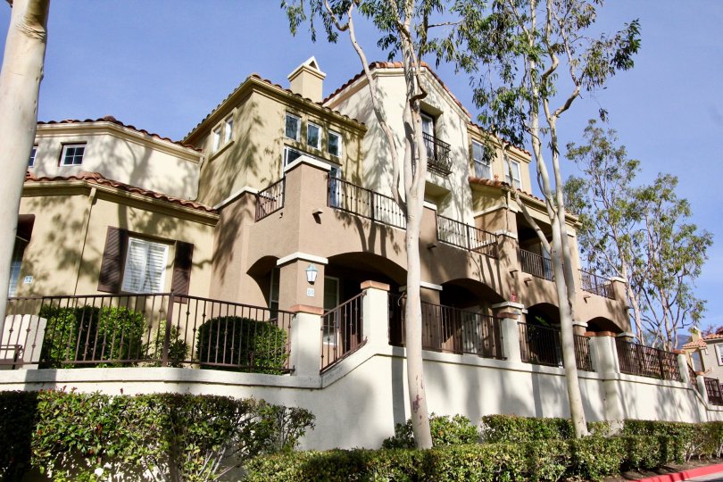 A beautiful day at the Spanish style Barcelona residences with wrought iron railings and tall trees