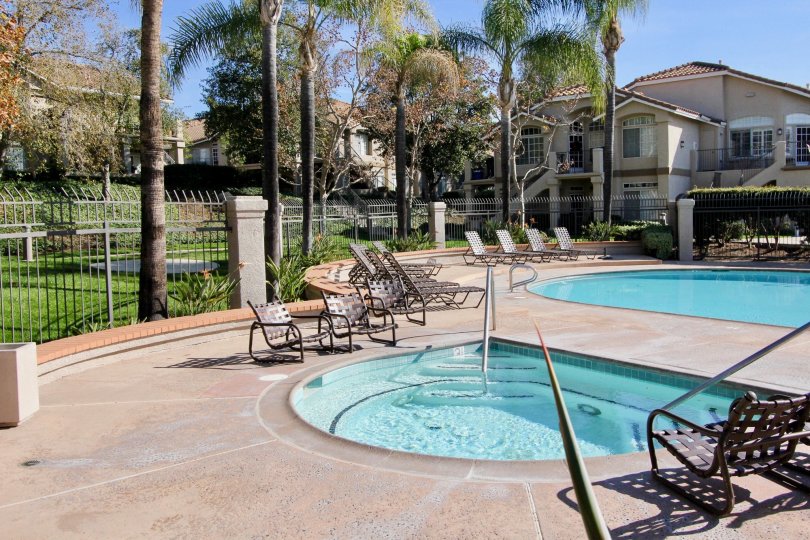 THE FLAT IN THE BELFLORA WITH THE TWO SWIMMING POOLS, CHAIRS, PLANTS, LAWN, TREES
