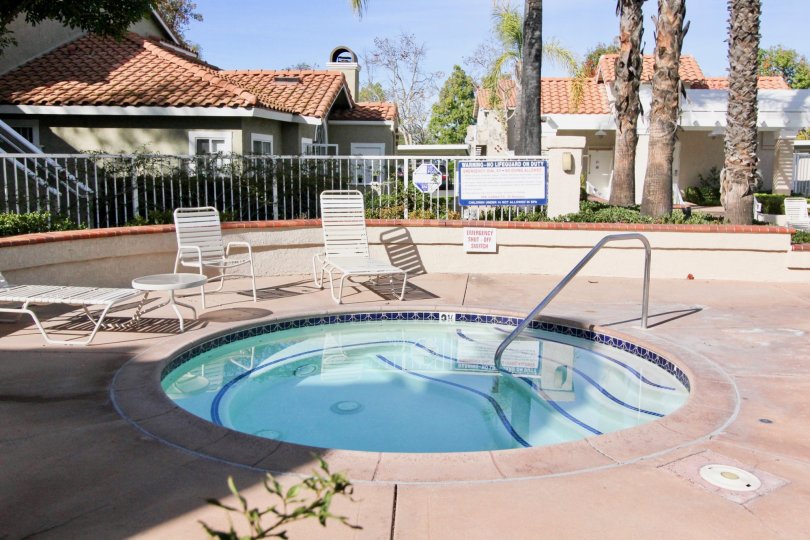 THE HOME IN THE LAS FLORES WITH THE SWIMMING POOL, CHAIRS, TREES, PLANTS