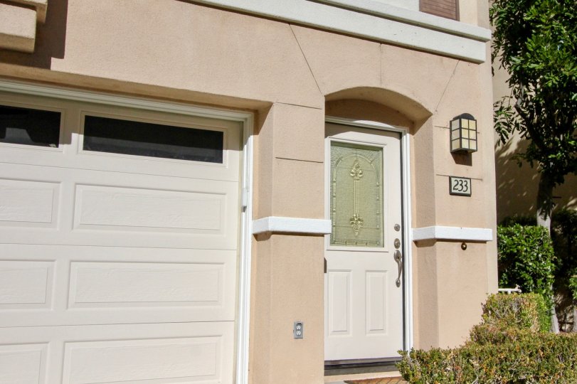 A low-rise residence painted in cream with closed carport in the Montana Del Lago community.