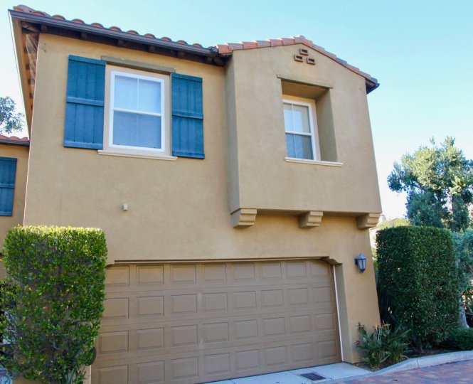 beige family home with blue window detail with garage