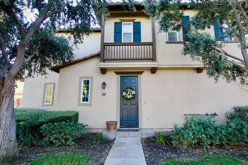 A holiday wreath sits on a blue door in the Alassio community