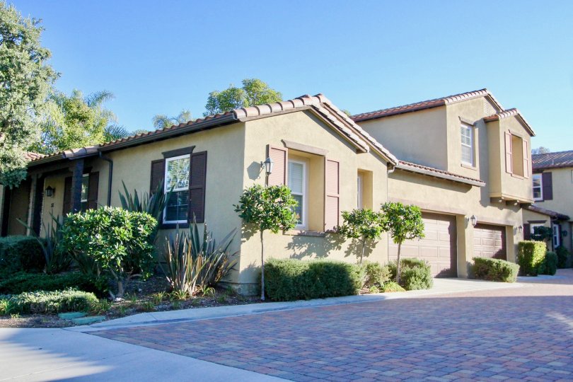 A colorful brick driveway sits in the shade at a townhome in the Alssio community