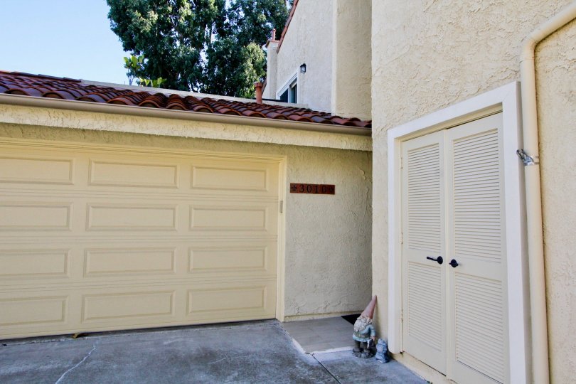 A closed carport with louvered back door access in the Sunset Village community.