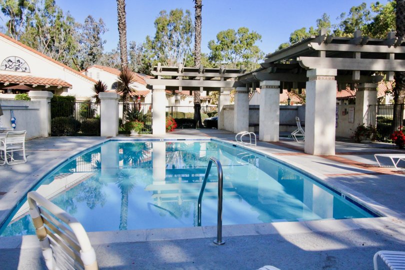 A pool with chairs and tables around it in Capistrano D'Oro community in San Juan Capistrano, California.