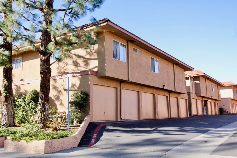 Salmon colored home with large windows and trees in the yard in Capistrano Villas.