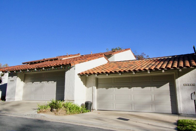 A sunny day with blue skies by a couple of garages in the Captains Hill area