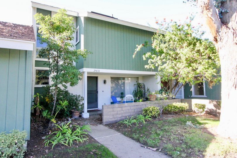 Green vertical slats of paneling sit on the second floor of a home at Village San Juan Townhomes