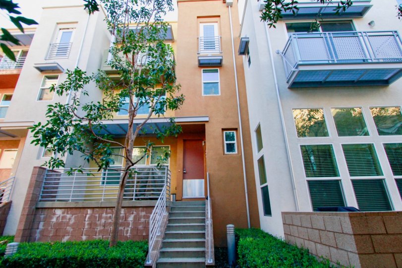 A multi storyed house with steps leading to a narrow front door in the city place community
