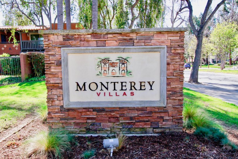 The brick sign of the Monterey Villas community on a sunny day.