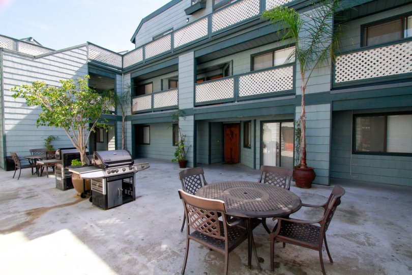 Dinning table and stove is present at center of the villa's in Pine vista with flower pots and plants