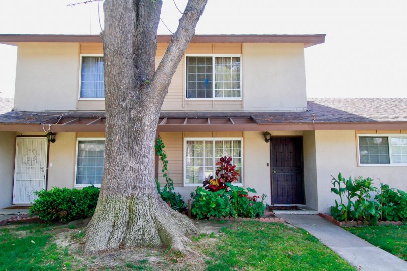 A frontal view of a mid size house with a garden in the Saddlebark park community