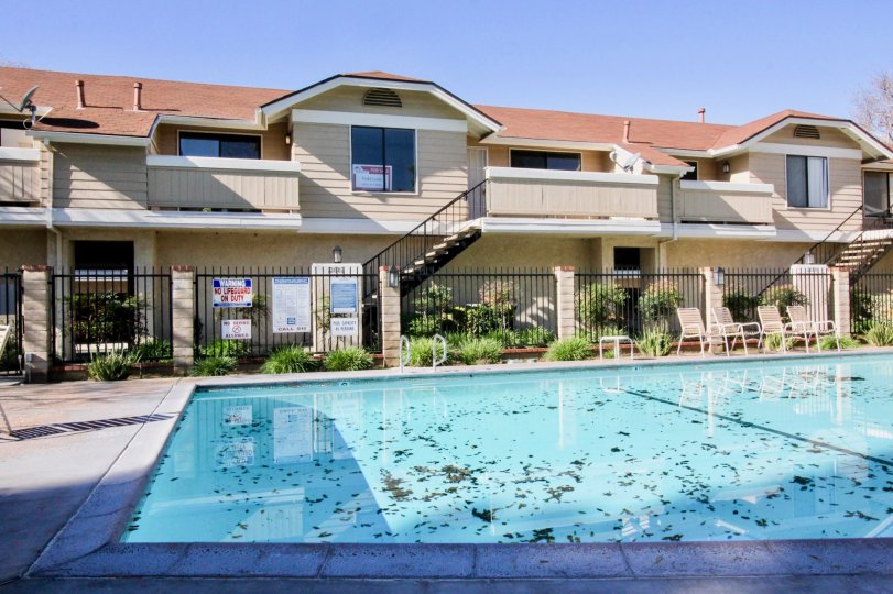 A large swimming pool in the Crosspointe Village with a building.