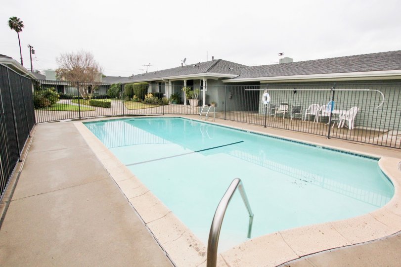 THIS Image represents the beautiful swimming pool which have the lot of chairs and views the longsite trees plants are there in the city of Tustin