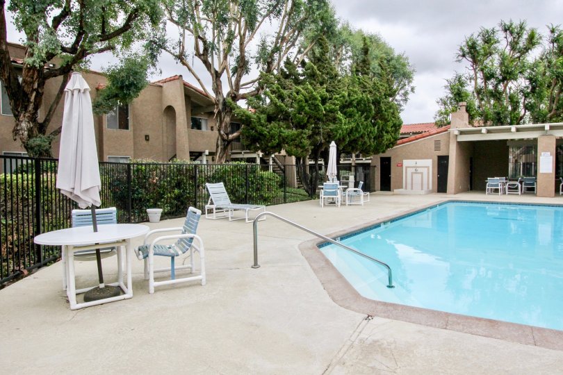 THE APARTMENT IN THE RANCHO SAN JUAN WITH THE TABLES, SWIMMING POOL, PLANTS, TREES