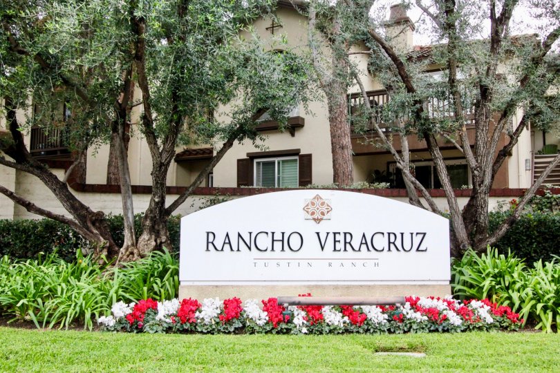 Large decorative community sign with professionally gardened flowers and mature trees in Rancho Veracruz