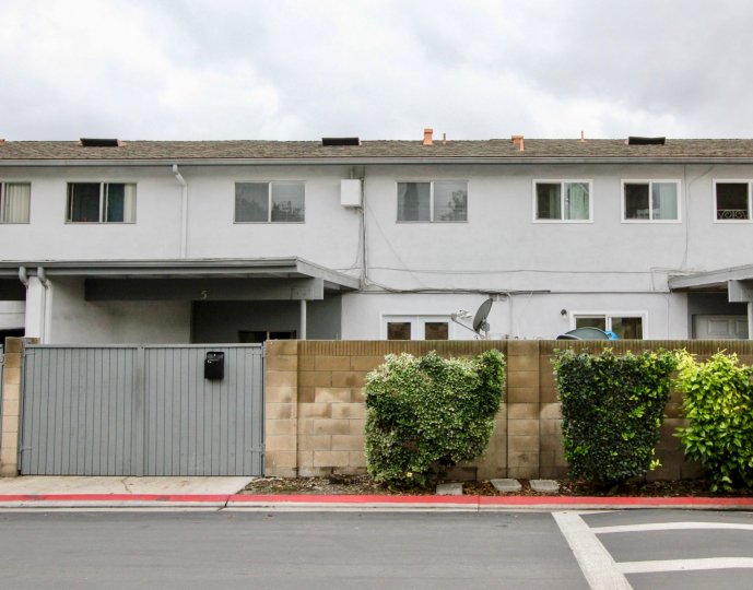 Two-storey townhouses with plain white walls and sliding windows in the Tustin Imperial community.