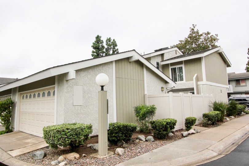 A white round bulb sits on top of a lamp post near a townhome in the Tustin Pines community