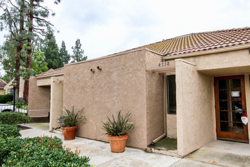 A tan single level building with visable number on it and is surrounded by trees and green bushes located in Lakeview community.
