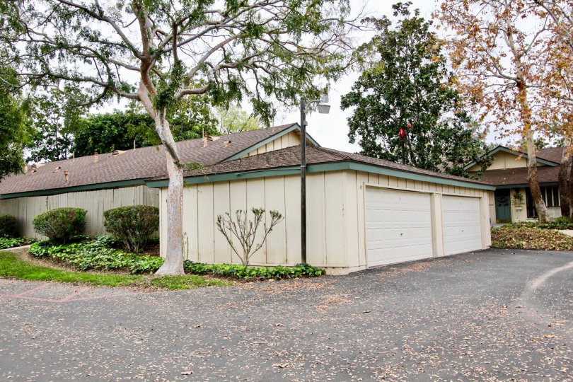 A shorter level garage with 2 doors and lots of green trees located in Rancho Linda community.