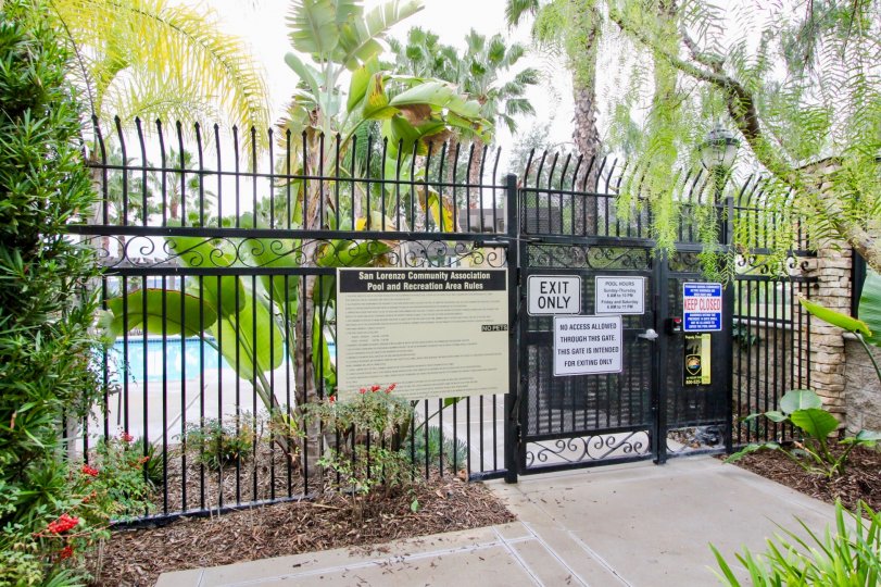 Few notice boards are attached at the gate of Swimming pool in San Lorenzo with plants and trees