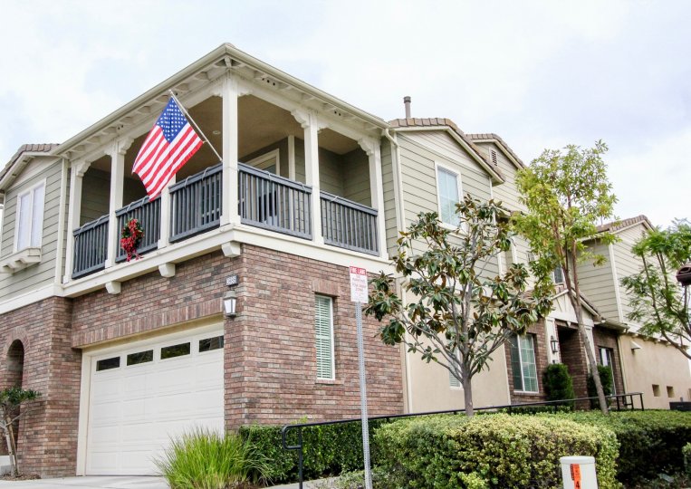A corner bunglow with an American flag hanging on the balcony railings in San Lorenzo community