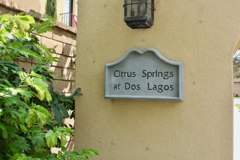 A decorative sign sits on a wall under a lamp at the Citrus Springs community.