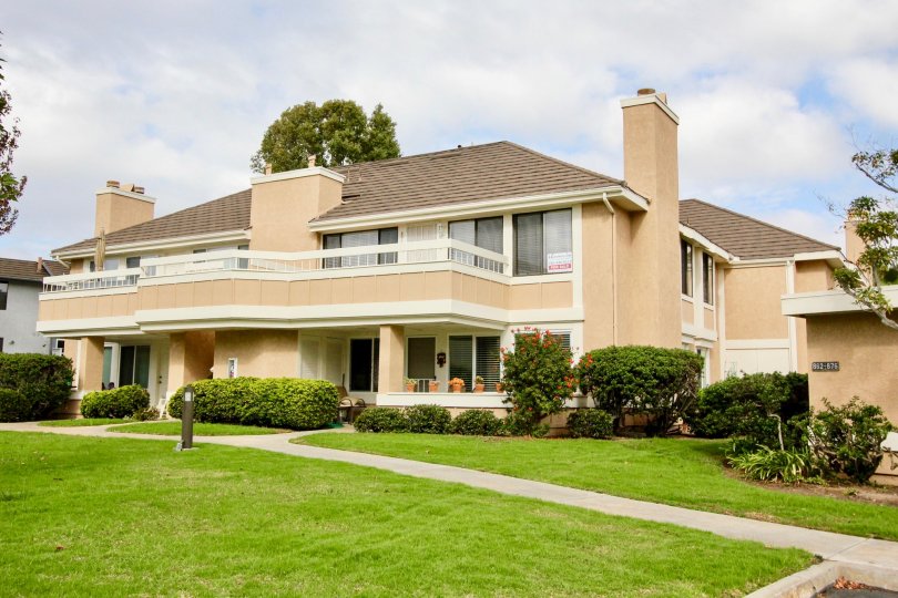 THIS PICTURE SHOWS THAT THE BUILDING IN THE CARLSBAD CREST WITH THE LAWN, PLANTS, TREES
