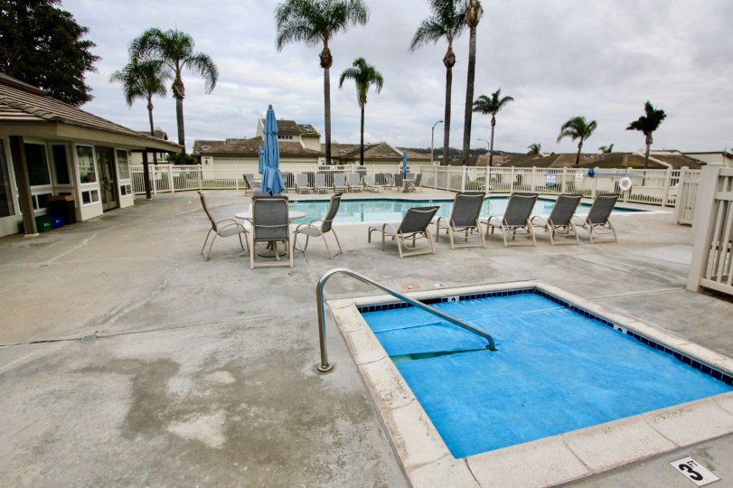 THE HOME IN THE LAGUNA DEL MAR WITH THE SWIMMING POOL, TREES, TABLES