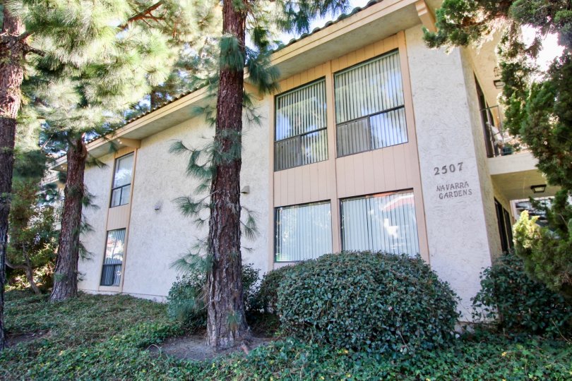 Apartment in Navarra Gardens has tall trees and bushes at side to the Navarra Gardens