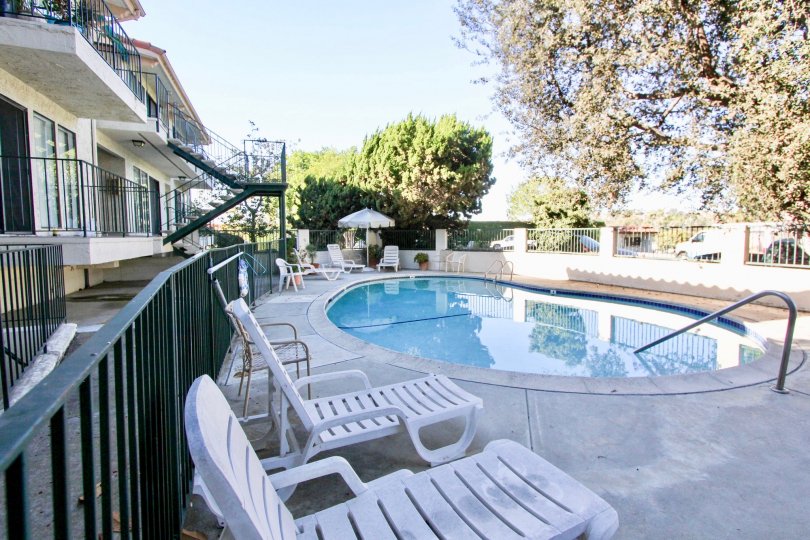 Inside the Apartment in Navarra Gardens has Swimming Pool with chairs and flower pots