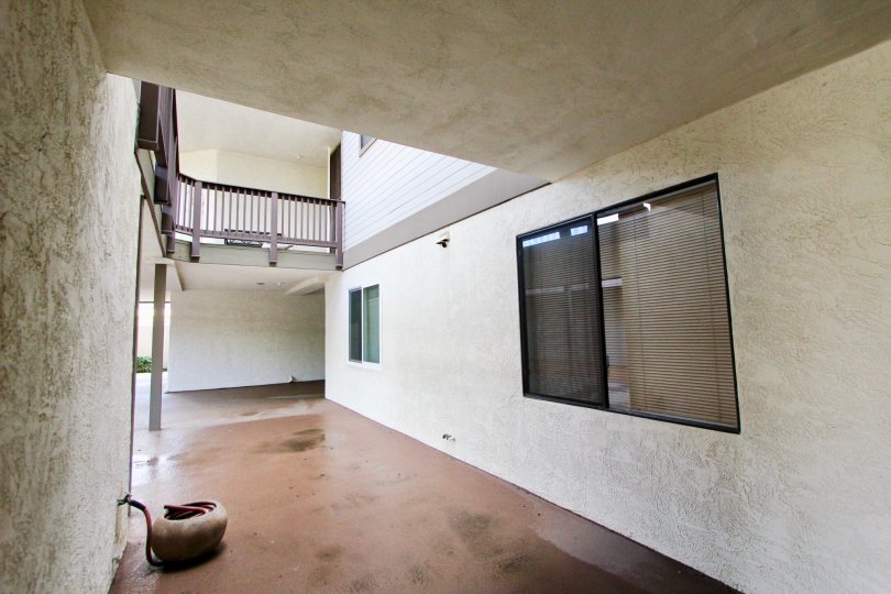 A courtyard portion of a big building in the Olive Point with glass window and balcony.