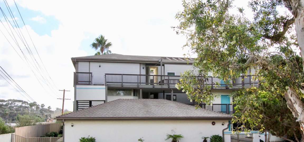 A tall white condominium build sits under a cloudy sky at Olive Point in Carlsbad CA